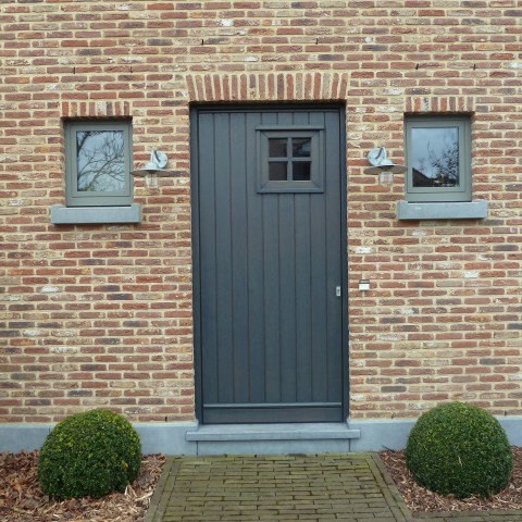 Zwart gebeitste houten pastorie inkomdeur met kijkvenstertje door Winfera in Hasselt geplaatst.