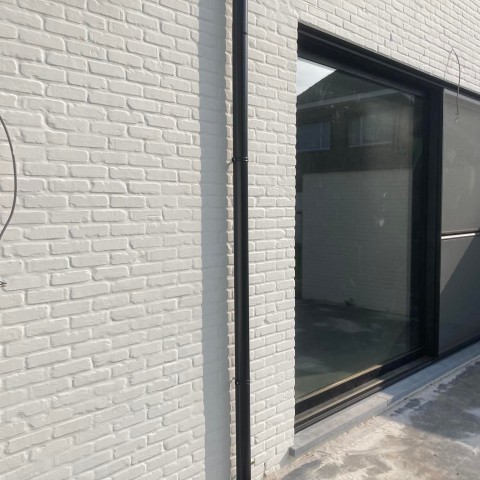 Modern PVC zwart schuifraam wit gekaleide muur